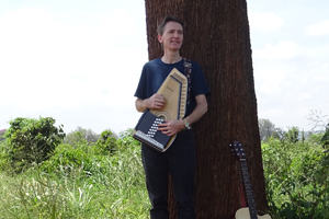 Den Miller stood leaning against a tree in a field 
