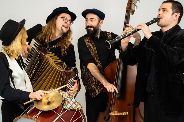 Klezmer Foygl image. The 4 band members are posing with their instruments. 