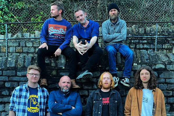 Nick Parker & The False Alarms image. </p>
<p>The 7 members are sat on a wall together.